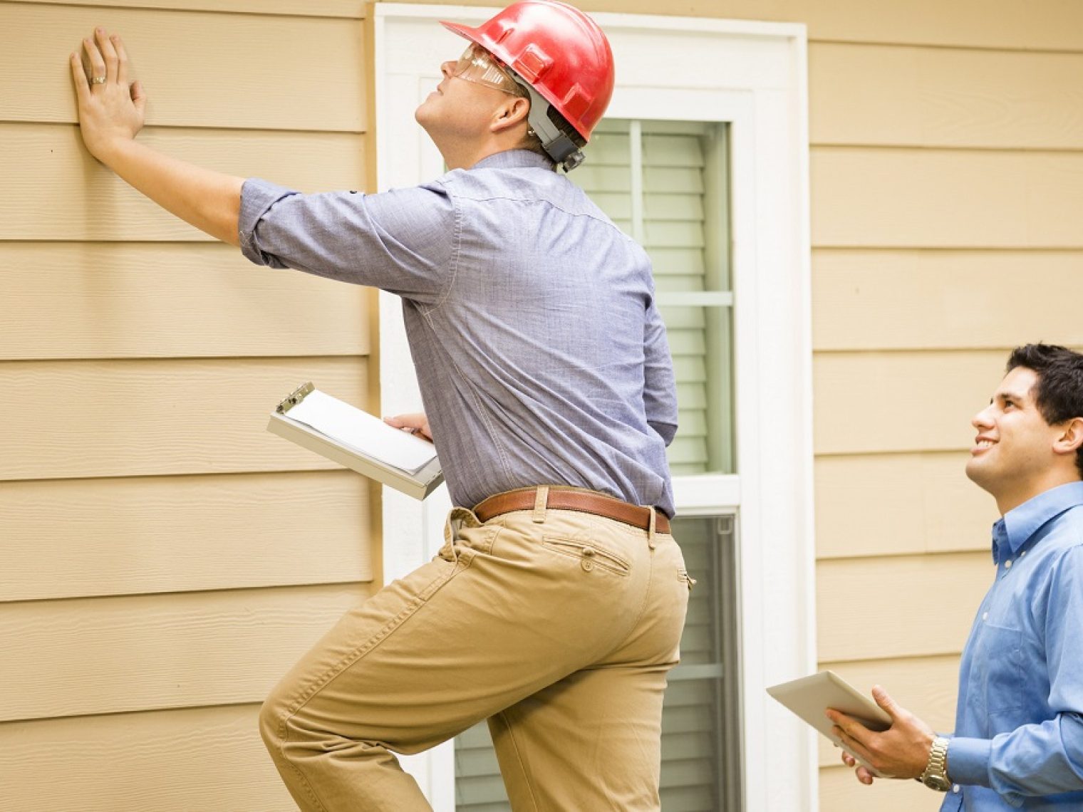 Two appraisers looking at the outside of a house.