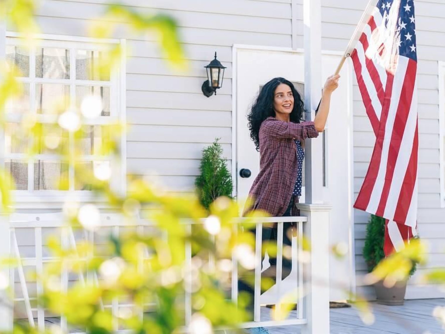 Veteran hanging American Flag on her front porch.