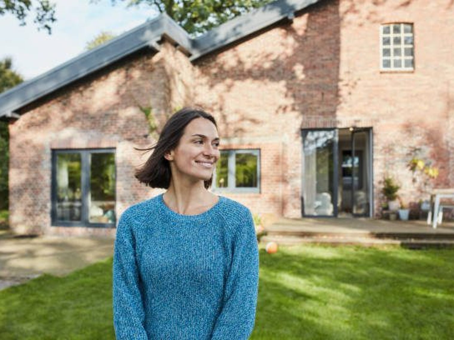 Woman in front of brick house